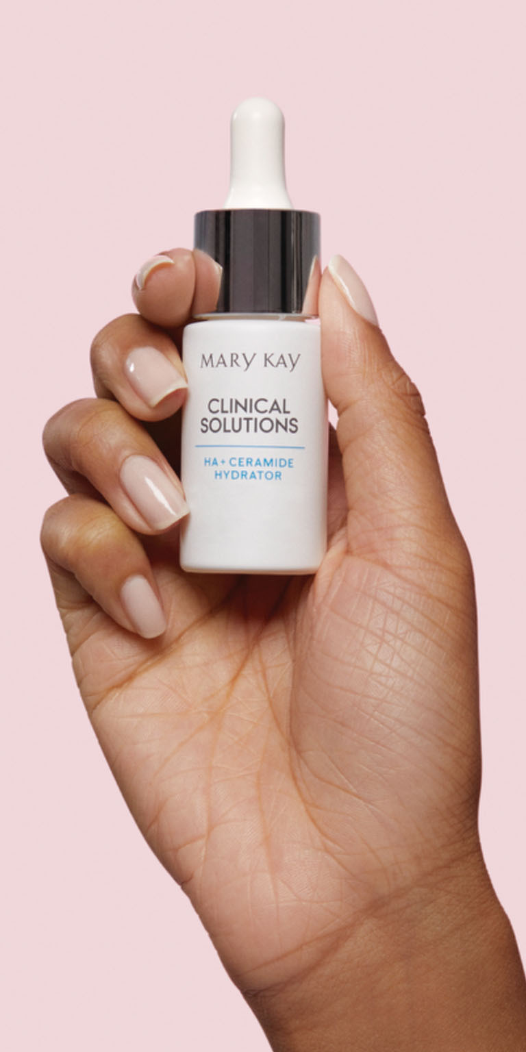 Model holding Mary Kay Clinical Solutions HA + Ceramide Hydrator bottle against a pink background